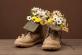 Boots with beautiful flowers on wooden surface Royalty Free Stock Photo