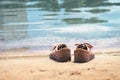 Footwear on the sand by the water of the lake. Shoes on the beach by the sea