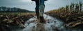Boots Walking Through Mud in a Field: Dynamic Agricultural Work Royalty Free Stock Photo