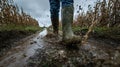 Boots Walking Through Mud in a Field: Dynamic Agricultural Work Royalty Free Stock Photo