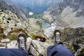 Boots of a woman sitting on the edge of a cliff in