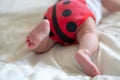 Booty baby in the body in the form of a ladybug. A newborn baby is lying on the belly. Baby is trying to crawl. Baby from the back