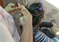 Boracay Island, Malay, Aklan, Philippines - A woman creates colorful braids on a customer\'s hair. A popular service i