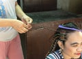 Boracay Island, Malay, Aklan, Philippines -A woman creates colorful braids on a customer's hair. A popular service i