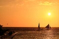 Boracay, Philippines - Jan 23, 2020: Sunset on the background of bottles standing on the bar. The sun passes through the bright