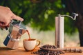 Boran coffee brewing that grinds coffee beans by hand Italian Moka pot with hot cups of coffee and coffee beans sprinkled on a Royalty Free Stock Photo