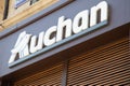 Auchan logo brand and text sign brown city entrance wall facade of French group of