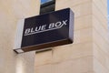 Blue box sign text logo of fashion sporty clothing store shop front in city street