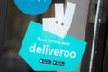 Deliveroo logo and text sign on windows restaurant to deliver on time the food to the