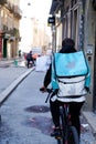 Deliveroo man with back bag on bike with logo sign of deliver restaurant online food