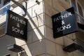 father & sons logo brand and text sign on wall facade shop entrance in city