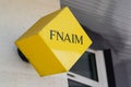 Fnaim cube brand logo yellow and text sign front of entrance office building real