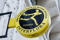 Interflora logo yellow and sign text on round panel street of florist shop and flower