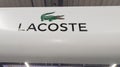 Lacoste brand logo in interior mall shop sign text on store front boutique
