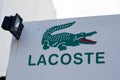 Lacoste brand logo in interior mall shop sign text on wall store front boutique