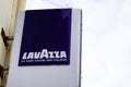 Lavazza logo and text sign of coffee shop advertising front of wall bar building