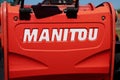 Manitou logo brand and text sign on red nacelle rental forklift tractor Telescopic