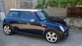 mini cooper black parked in the street in side view