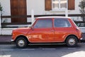 Mini Cooper Classic in coral red colors classic British car in side view street Royalty Free Stock Photo