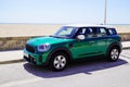 MINI countryman car in racing green color side view in sea beach coast