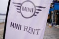Mini rent logo text and brand car sign on flag front of dealership vehicle store