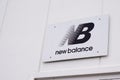 New Balance logo brand and text sign on white facade shop entrance official store of