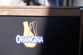 Orangina orange lemonade logo sign and brand text on panel on the terrace of the cafe