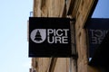 Picture shop brand logo and sign text on facade fashion store