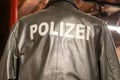 Polizei text sign on the back of german police man wearing leather jacket rear view