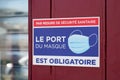 Port du masque obligatoire text french sign on wall store entrance against covid 19