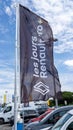 Renault dealership store car sign text and brand logo on black winding flag in cloudy