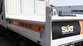 Sixt logo brand and text sign for Car Rental on construction dump truck