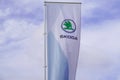 Skoda store dealership sign and text logo on flag on wind of car Czech automobile