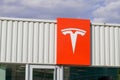 Tesla car text sign and red logo front of store ev showroom of dealership electric