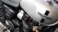 Triumph Motorcycle logo and text sign on grey modern fuel tank of British motorbike