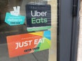 Uber eats deliveroo and just eat sign brand and text logo front of windows of