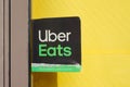 Uber eats sign brand and text logo front door windows of restaurant company shop food