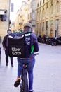 Ubereats delivery man on bike cycle deliver take away restaurant with brand back bag