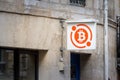 Bitcoin logo in front of a bitcoin shop in Bordeaux, France, where you can physically buy cryptocurrencies such as BTC