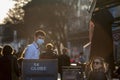 Selective blur on french Waiter server in uniform working at terrace of a cafe serving drinks to client wearing face mask on covid