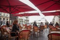 Selective blur on a client, a woman, alone sitting at the terrace of a French brasserie, or cafe