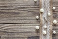Border of burlap with white lace and beads on old wooden table. Royalty Free Stock Photo