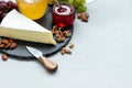 Border of camembert or brie cheese on plate slate on gray wooden background with nuts, grapes, honey and cherry jam. Italian food Royalty Free Stock Photo