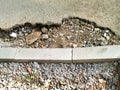 Repair of the sidewalk, road construction. A border of cement and stacking of stone gravel. Holes in the asphalt surface. Royalty Free Stock Photo