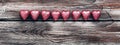 Border chocolate candy heart in a pink wrapper on a vintage wooden background. View from above Royalty Free Stock Photo