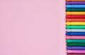 Border of colored felt tip pens on pink background with place for text. Top view Royalty Free Stock Photo