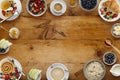 A border of delicious breakfast plates, pancakes and pasteries, bowls of fruit and porridge, and cups of coffee, on a rustic Royalty Free Stock Photo