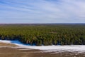 On the border of forest and field the snow melts. Aerial shot