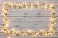 A border of golden star christmas lights, on a destressed woodern background