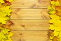 Border made from autumn colored maple leaves on wooden boards background, copy space Royalty Free Stock Photo